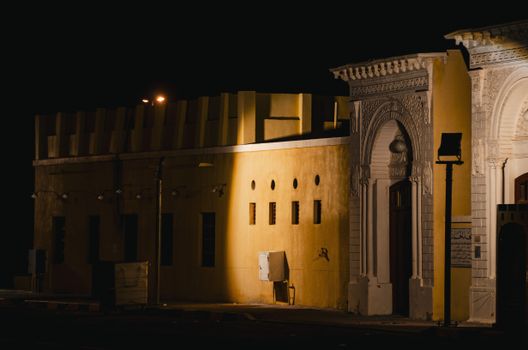 A detailed view of a traditional Kuwaiti building illuminated at night.