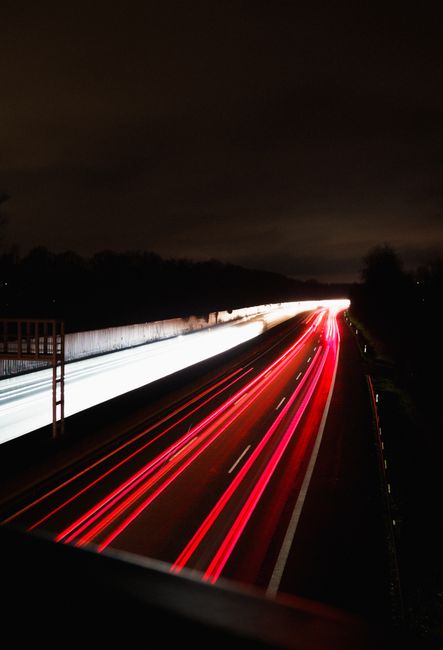 Highway at night capturing red and white light trails, creating a vibrant display in Unna, NRW.