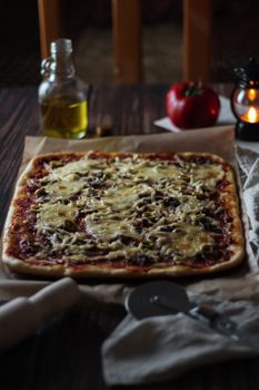 Savor the taste of a homemade cheese and olive pizza fresh from the oven, perfect for a cozy indoor meal.