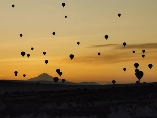 Silhouette of Balloons over Mountains 