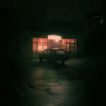 Moody night scene with a retro car in front of an illuminated Baku restaurant.