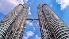 在晴朗的蓝天下，从低角度拍摄的吉隆坡标志性建筑——马来西亚国家石油公司双子塔