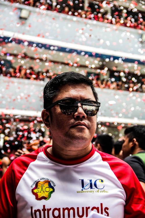 빨간색과 흰색 위쪽 및 검은 색 선글라스를 착용하는 남자