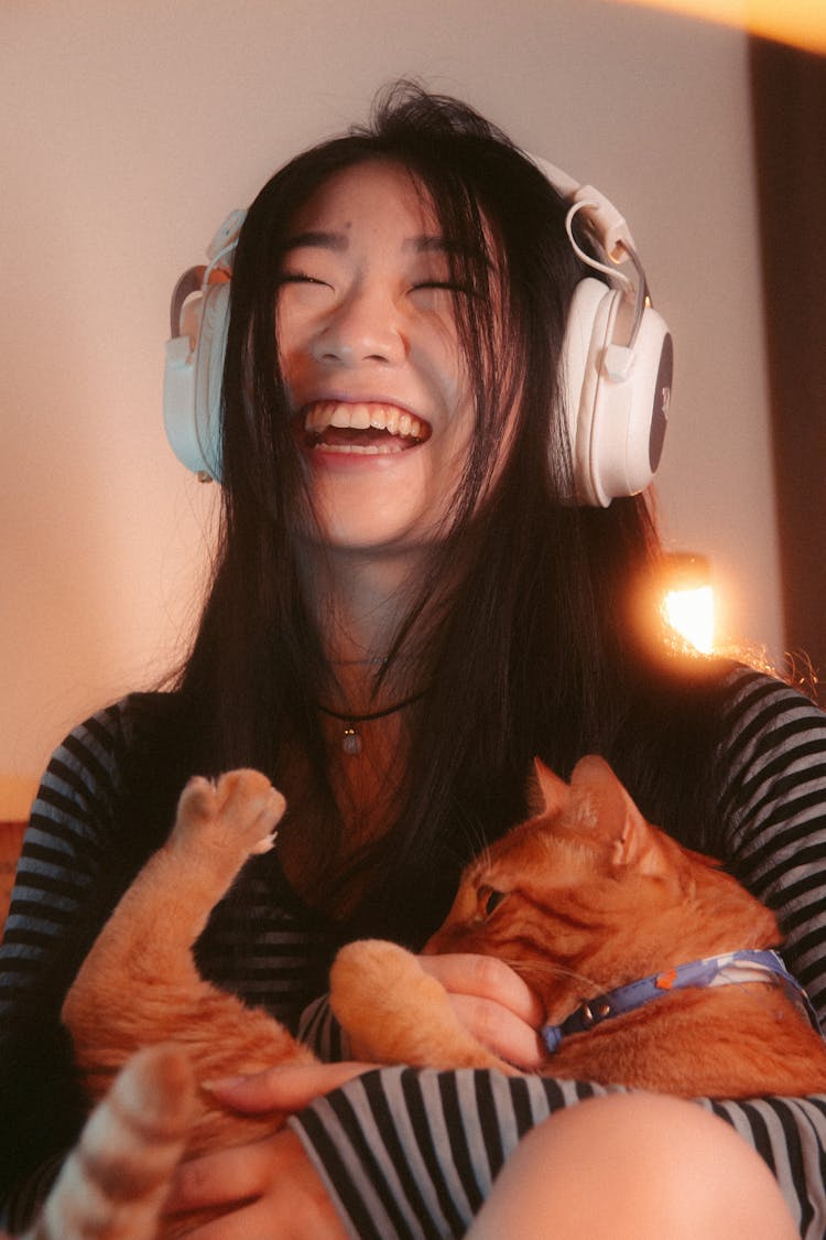 Laughing Woman In Headphones And With Cat