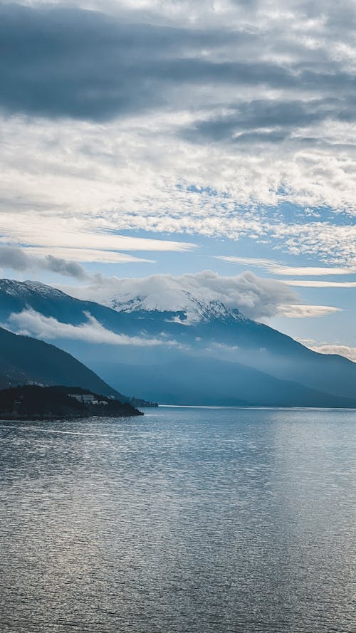 An Ocean Near the Mountain Under the Cloudy Sky