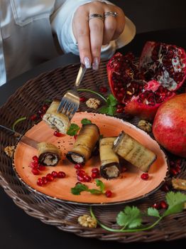Savor the taste of aubergine rolls complemented by fresh pomegranate seeds for a delectable experience.