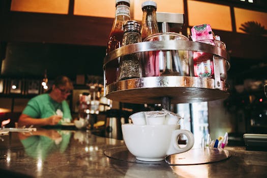 Close-up of a coffee station with condiments on a diner counter, creating a warm atmosphere.