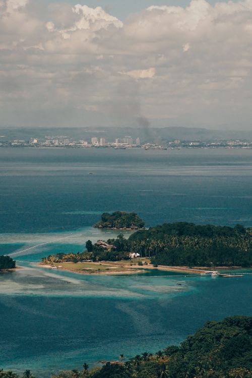Free Stunning aerial view of the Samal Island coastline, highlighting lush nature and sparkling waters. Stock Photo