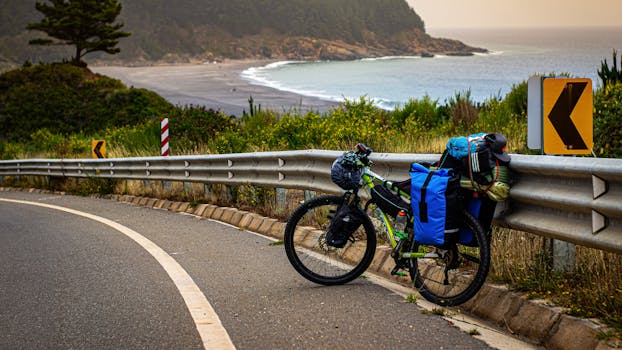 Bicycle adventure along a coastal road with beautiful beach view and directional signs. Ideal for travel themes.