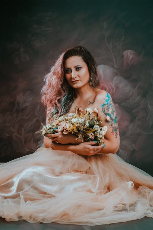 Woman in a Tulle Dress Holding a Bunch of Flowers