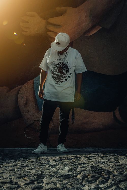 Free Stylish urban fashion portrait of a man in streetwear, captured in Puebla, Mexico against a mural backdrop. Stock Photo