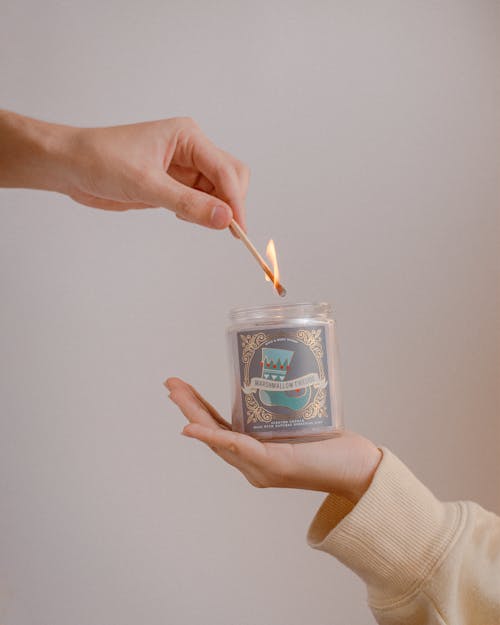 Hand Lighting the Candle Inside the Glass Jar 