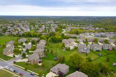 Aerial view of a suburban neighborhood with houses, roads, and lush greenery.