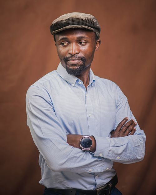 Free Portrait of a stylish man wearing a hat and wristwatch in studio setting. Stock Photo