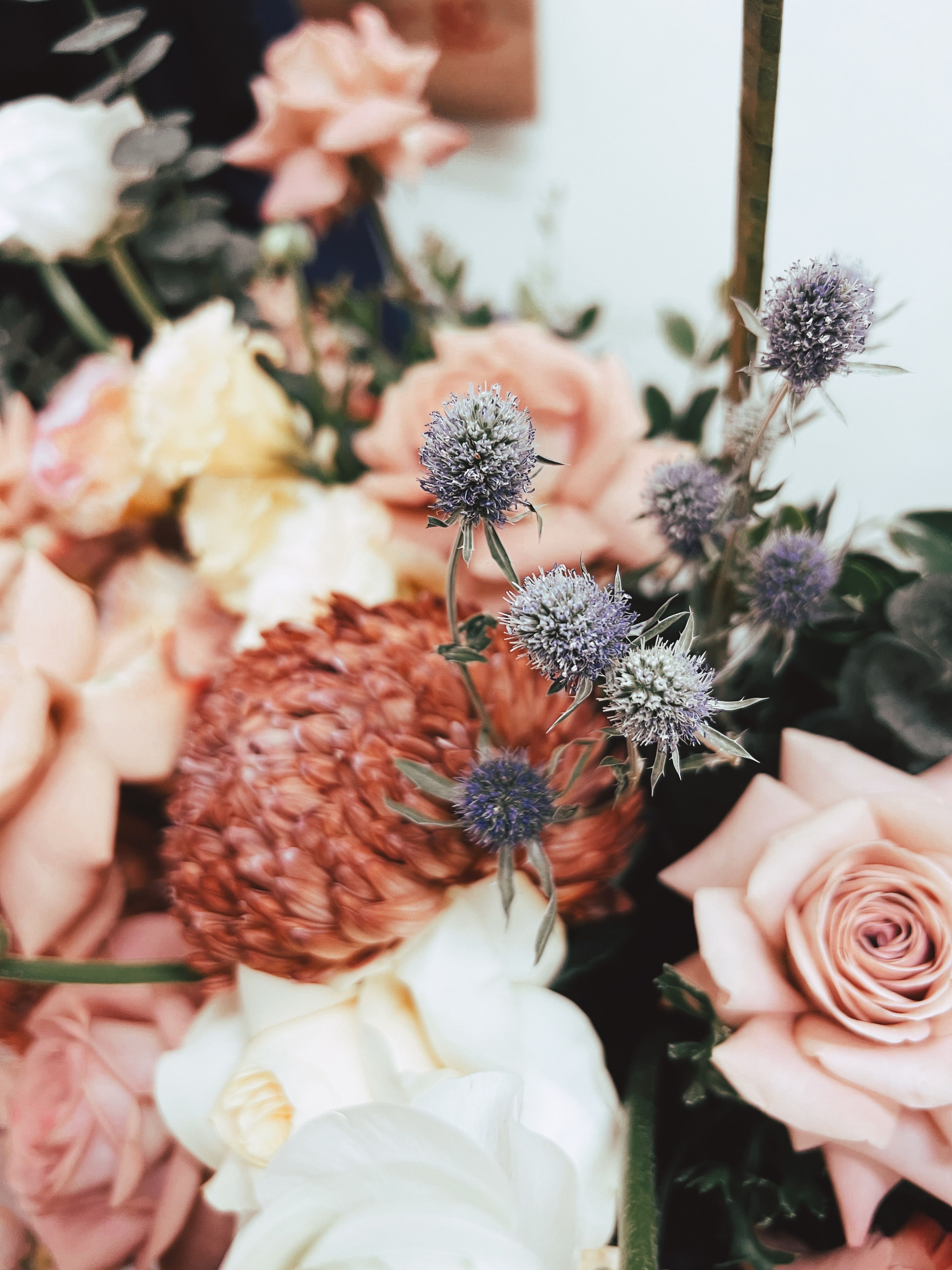 Close-up of a stylish flower arrangement featuring pink roses and assorted blossoms.