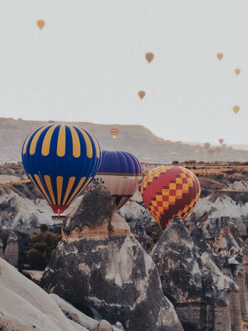 Free A stunning view of vibrant hot air balloons floating over unique rock formations, capturing the essence of adventure. Stock Photo