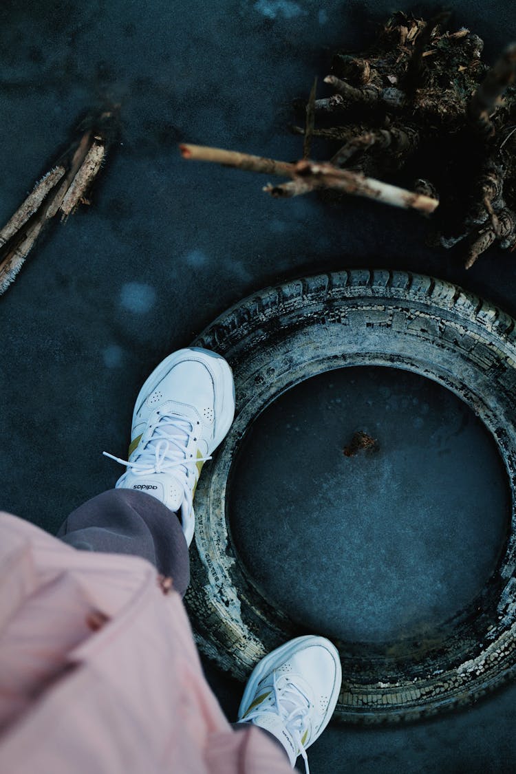 Person Standing On A Tyre On A Frozen Surface 