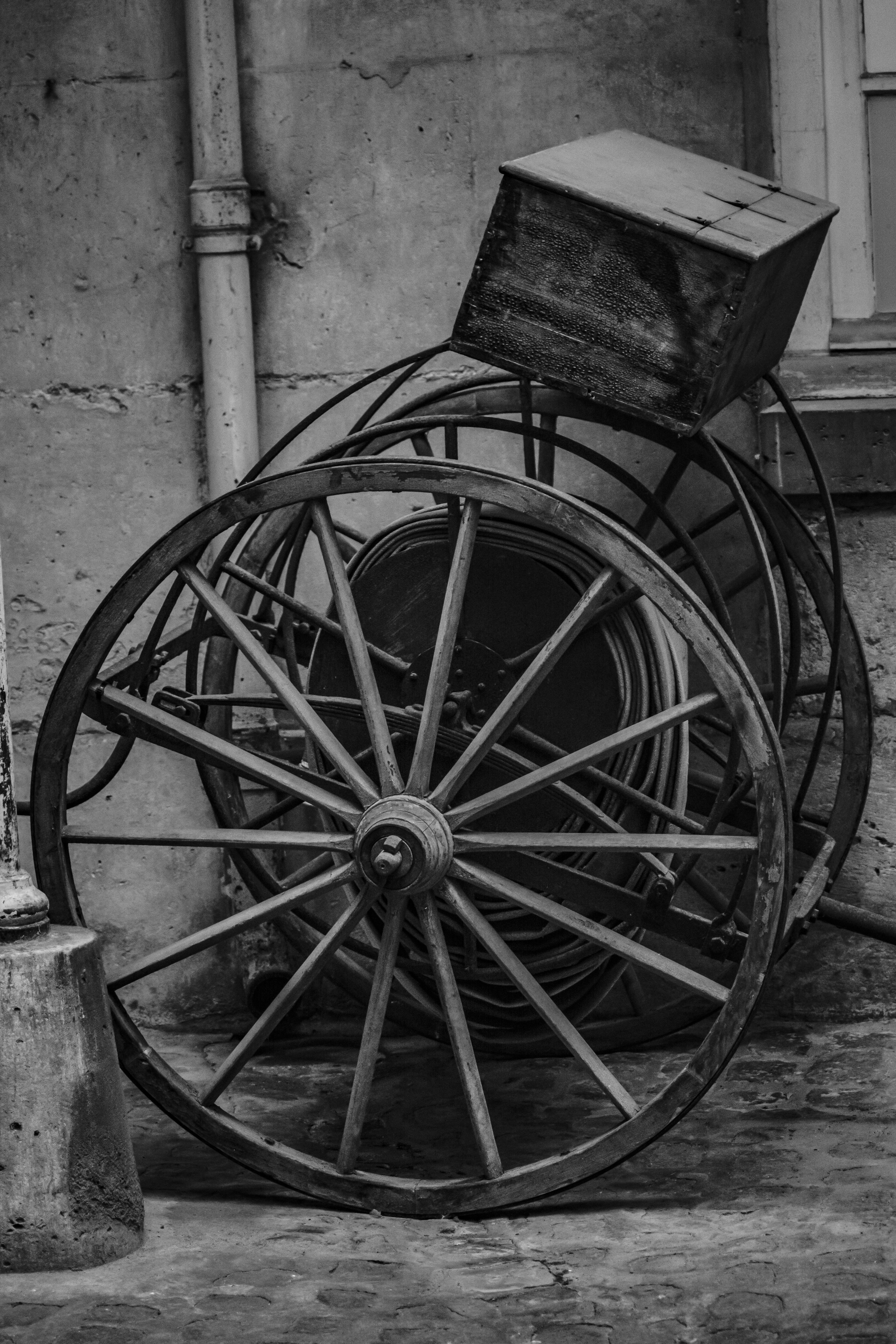 Box on Wooden Wheels near Wall · Free Stock Photo