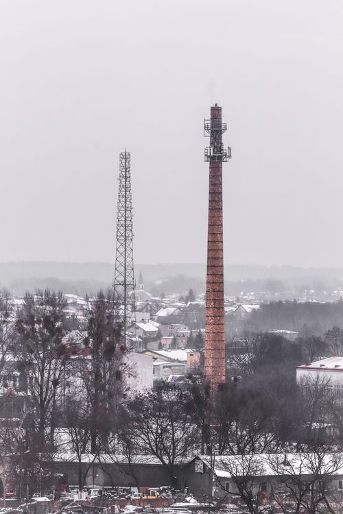Free A tall chimney in snowy Białystok, Poland, showcasing winter industry. Stock Photo