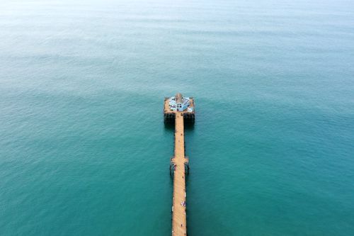Free Stunning aerial shot of Oceanside Pier reaching into blue waters, showcasing serene oceanic beauty. Stock Photo