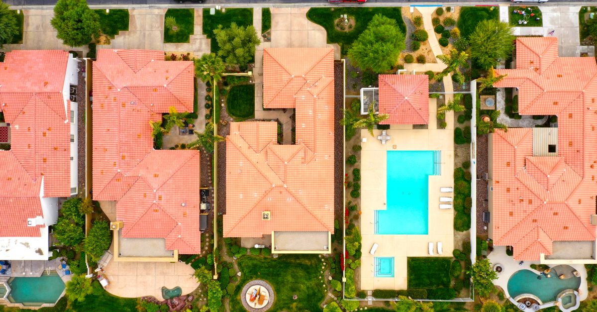 Aerial view showing suburban homes with pools in La Quinta, California, highlighting luxury lifestyle.