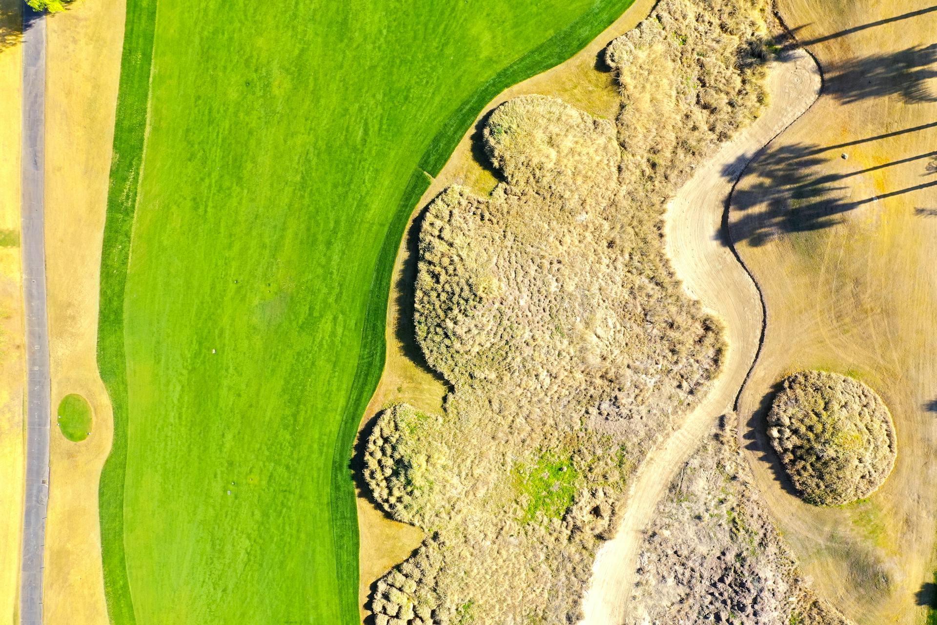 Aerial shot showcasing a lush golf course and arid landscape in La Quinta, California.