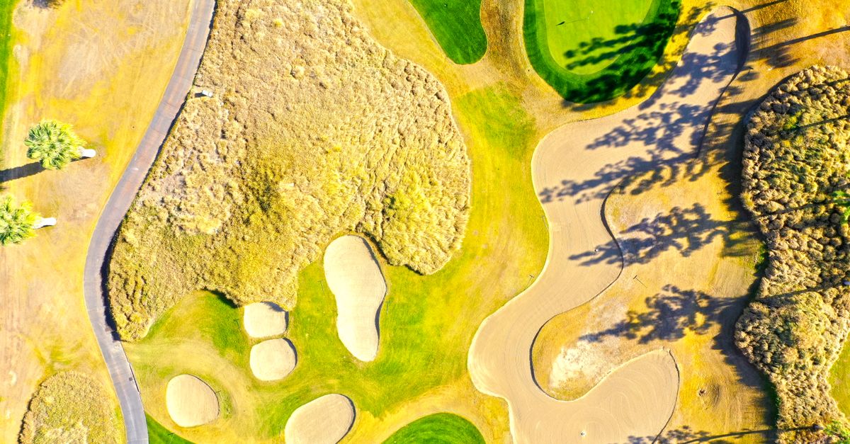 A vibrant aerial capture of a golf course in La Quinta, showcasing sand bunkers and green lawns.