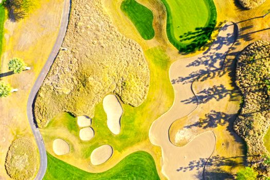 A vibrant aerial capture of a golf course in La Quinta, showcasing sand bunkers and green lawns.