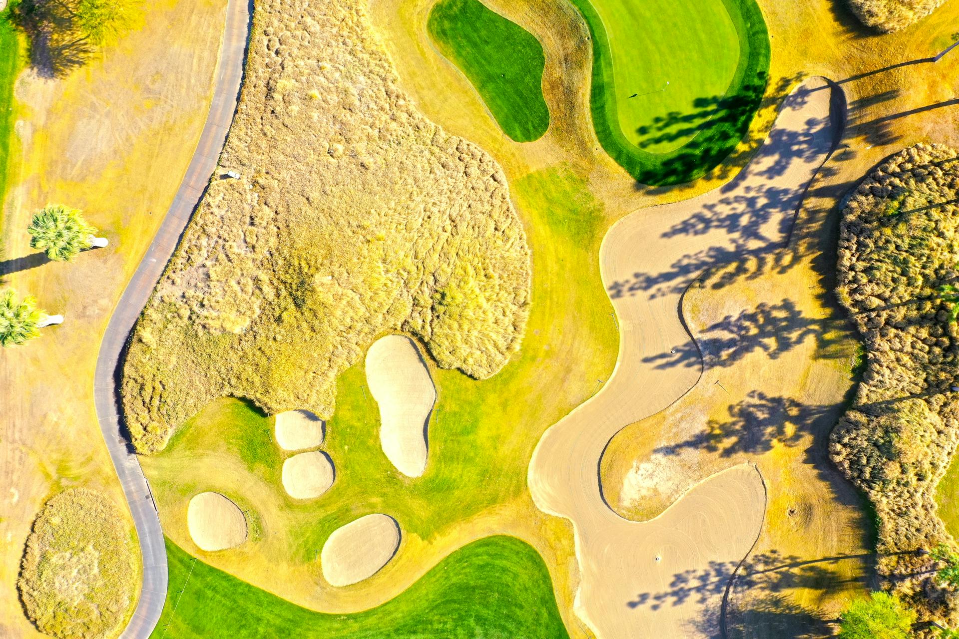 A vibrant aerial capture of a golf course in La Quinta, showcasing sand bunkers and green lawns.