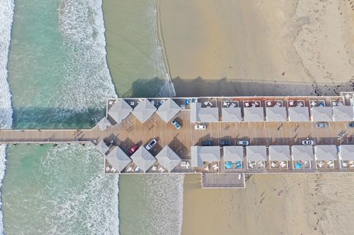 Free Stunning aerial photograph of a pier with cars and beach waves in San Diego, California. Stock Photo