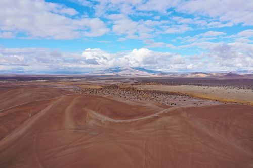Free Stunning aerial view of rugged desert dunes against a backdrop of blue sky and mountains in Beatty, Nevada. Stock Photo