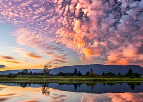 Captivating sunset with vibrant clouds and serene reflections over Pitt Meadows, BC.