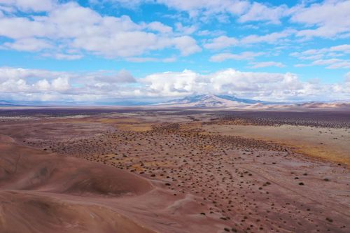 Free An expansive aerial view of the desert landscape in Beatty, Nevada with clouds and distant mountains. Stock Photo