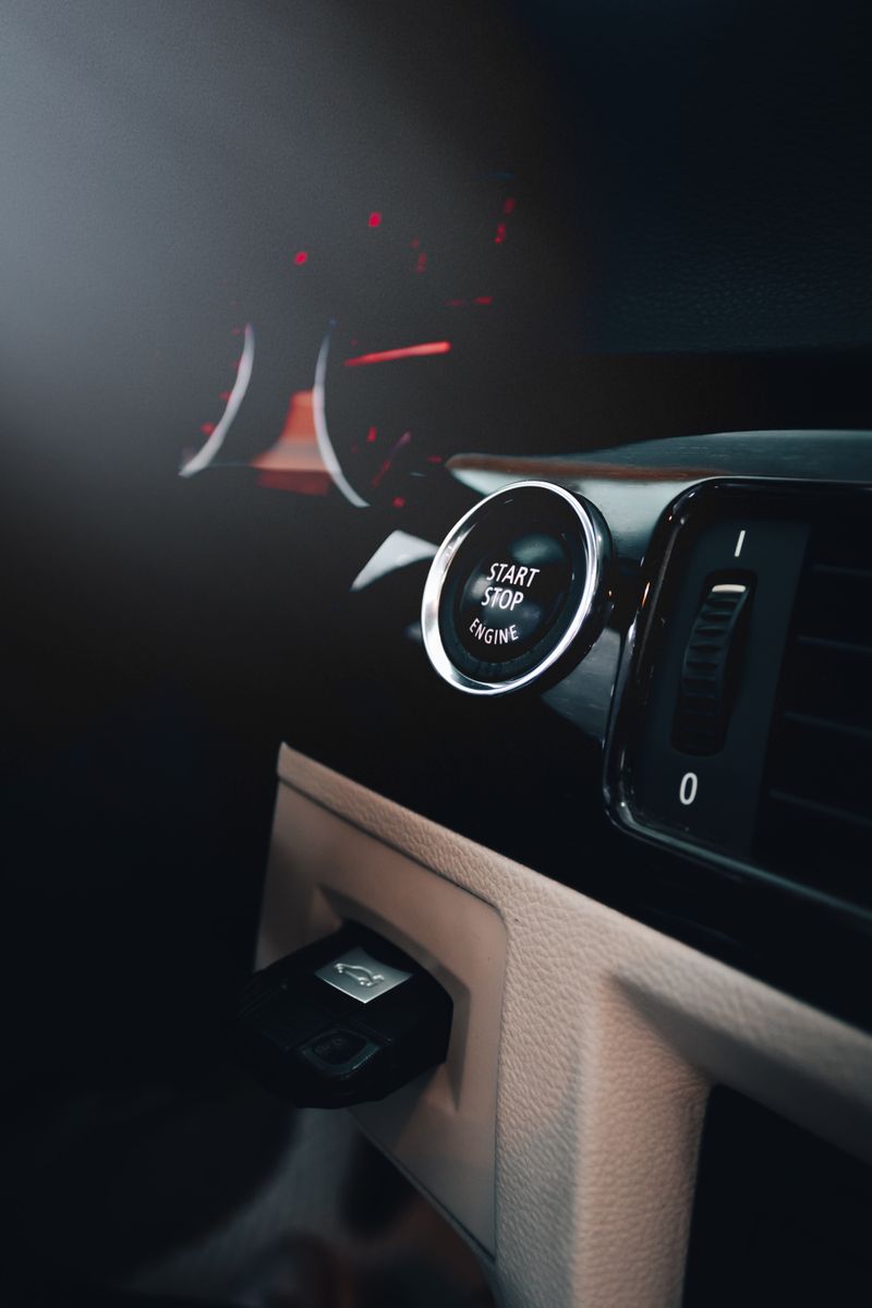 Close-up of a car's dashboard featuring an illuminated start-stop button.