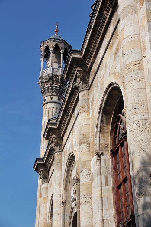 Free Close-up of a historic stone building tower under a clear blue sky. Stock Photo