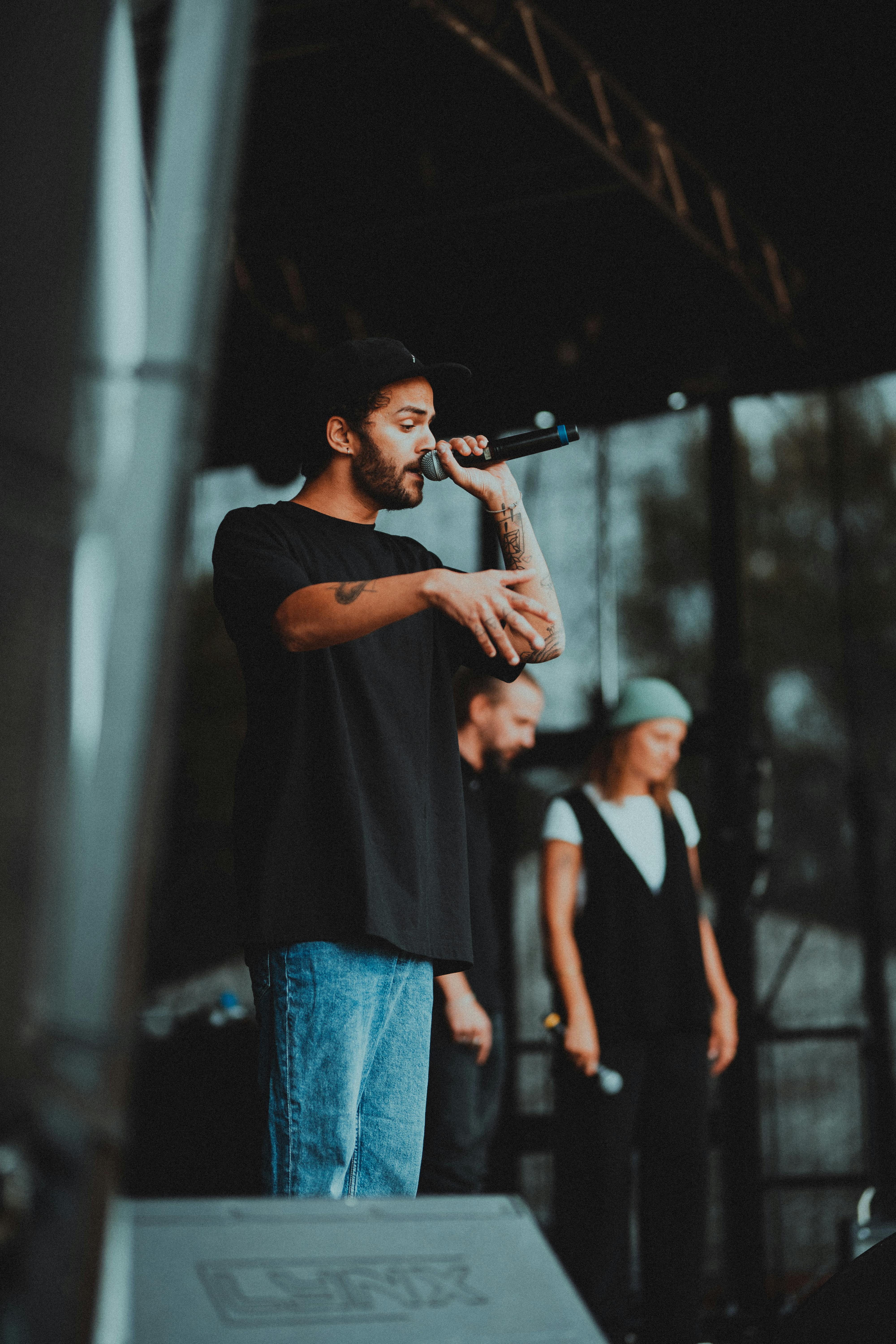 Outdoor concert featuring diverse artists performing live on stage with microphones.