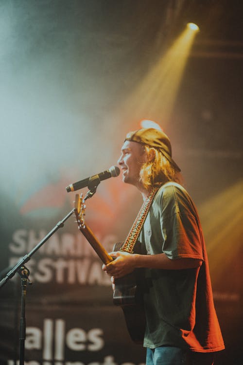 Man Singing While Holding a Guitar