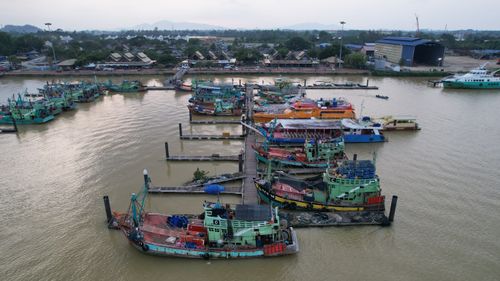 Free Aerial shot of colorful fishing boats moored in Kuala Terengganu harbor, Malaysia. Stock Photo