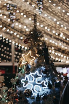 Close-up of a Christmas tree adorned with lights and glowing decorations.