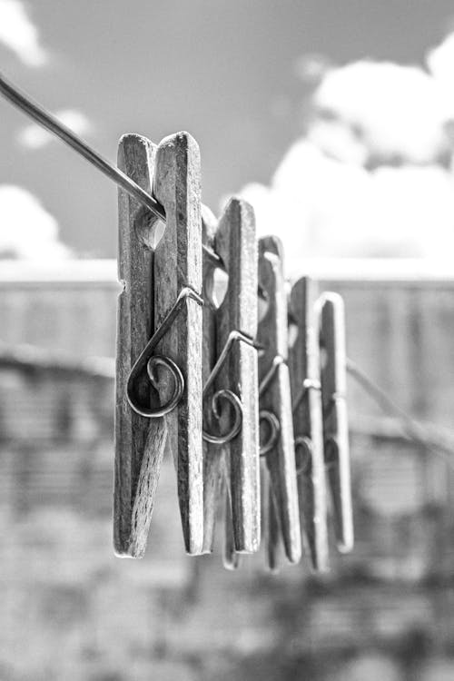 Grayscale Photo of Wooden Clothes Pins