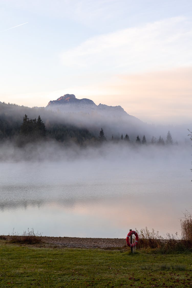 Foggy Mountains Near Body Of Water