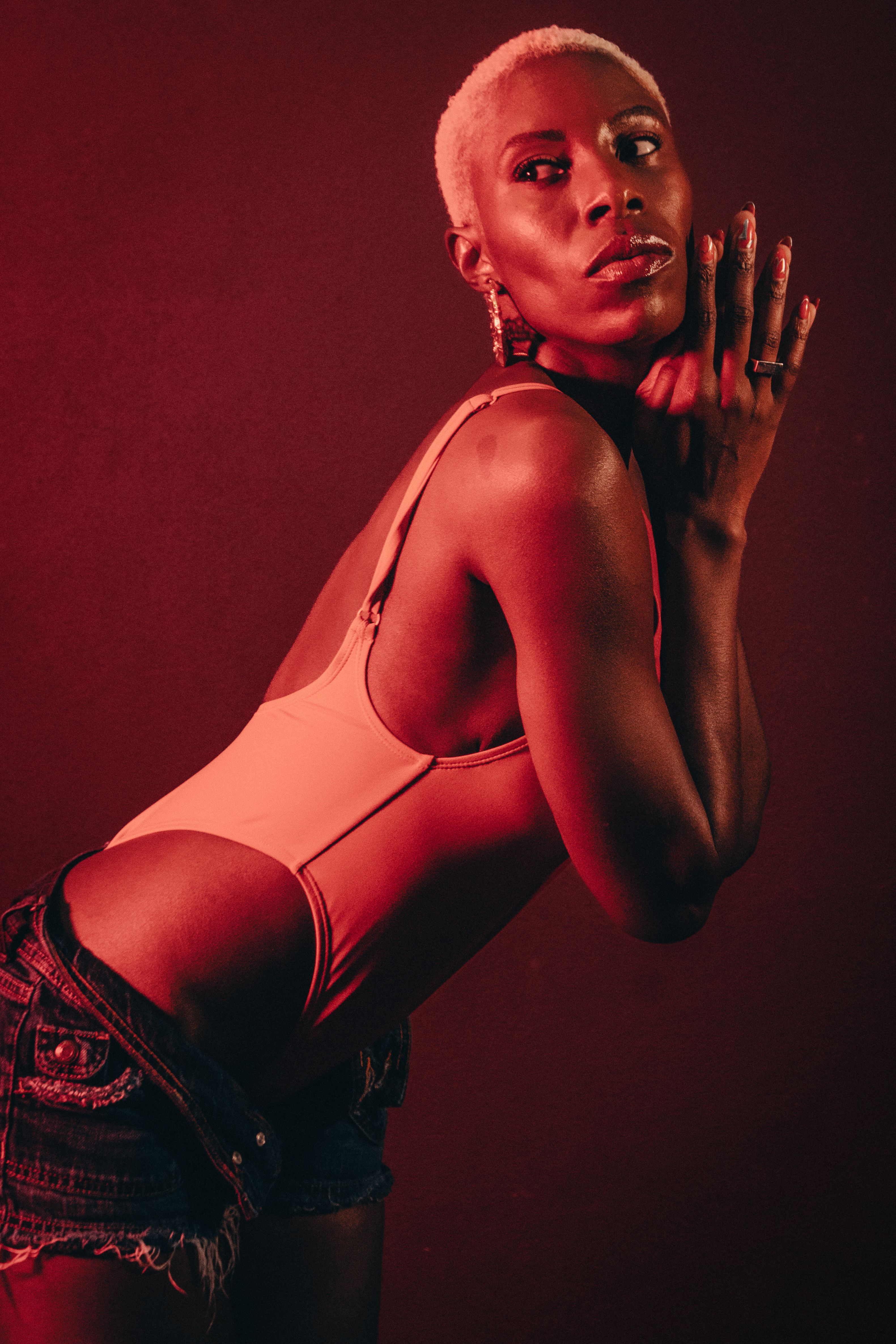 Elegant studio portrait of an adult woman in red lighting, exuding style and confidence.