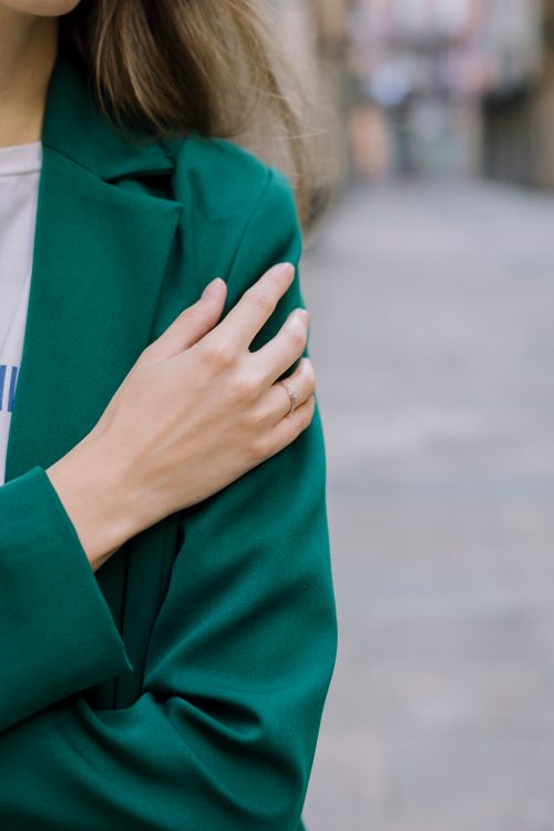 Free Close-up of a woman in a stylish green blazer with a focus on elegance and modern fashion. Stock Photo