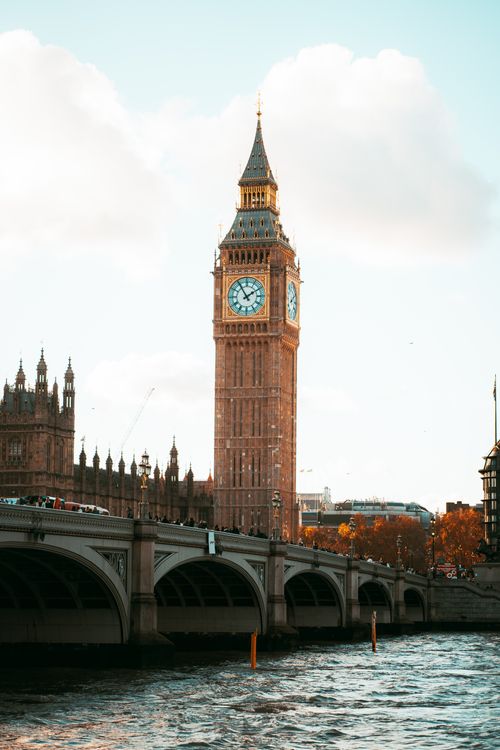 Free Captivating view of Big Ben and Westminster Bridge framed by autumn leaves under a bright sky. Stock Photo