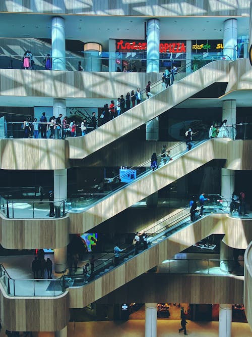 People Riding Escalators in a Shopping Mall