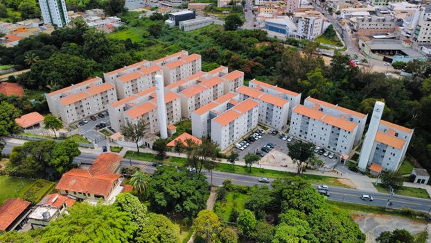 Aerial view showcasing a modern apartment complex surrounded by greenery in MG, Brazil.
