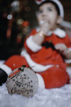 A cute baby dressed as Santa celebrates their first Christmas. Perfect for festive holiday themes.