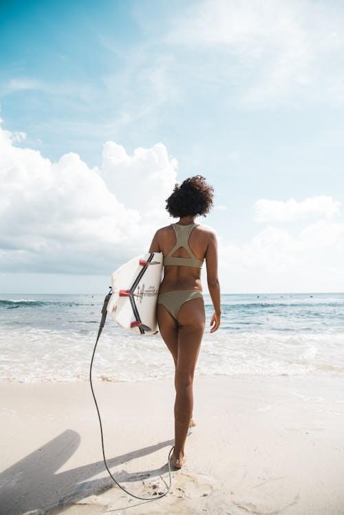 Woman Walking with Surfboard on Beach