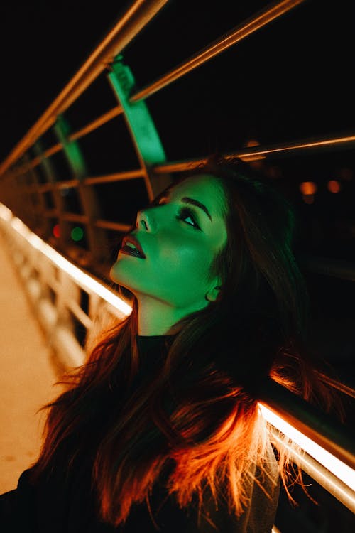 Woman Posing near Illuminated Bridge at Night