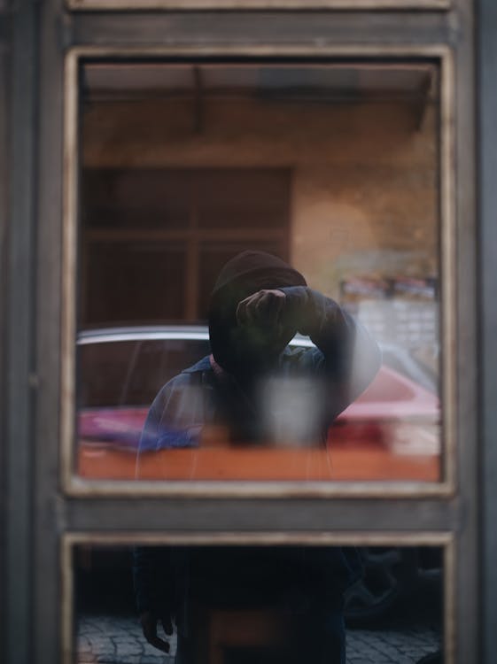 A Window with a Reflection of a Man Taking a Picture with a Camera ...
